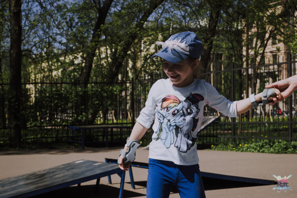 Adult beginner learning to balance on a skateboard with Vladimir's support