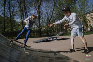 Young beginner riding a ramp for the first time with Vladimir guiding