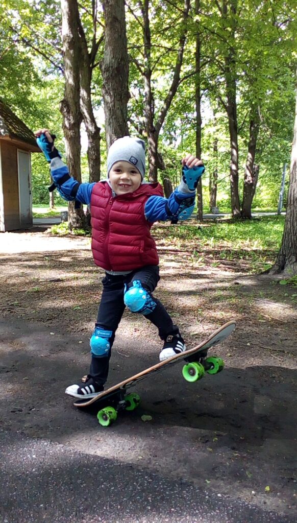 Beginner skateboard lessons in Sydney: young beginner in a helmet and pads learning with One2Flip