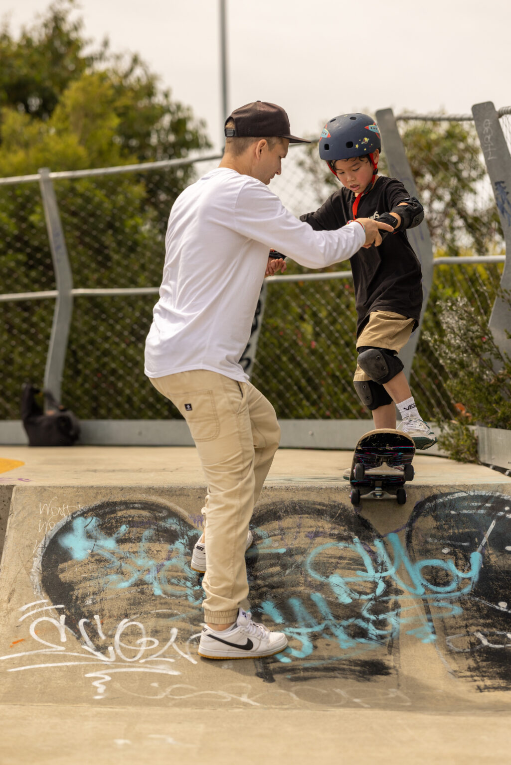 Vladimir helping a student balance on a skateboard, Sydney