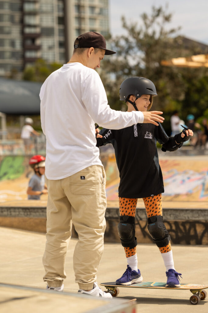 Vladimir coaching two young skaters together on the ramp at a Sydney skatepark