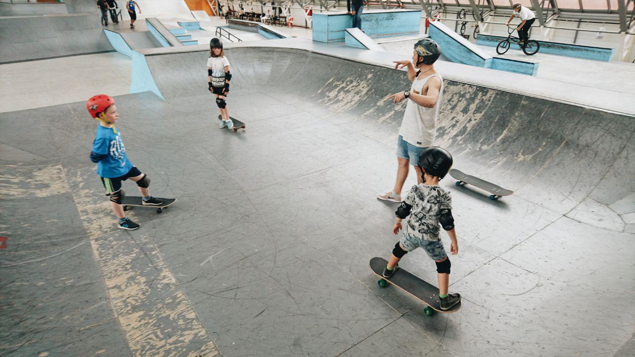 Small group skateboarding session at an indoor skatepark