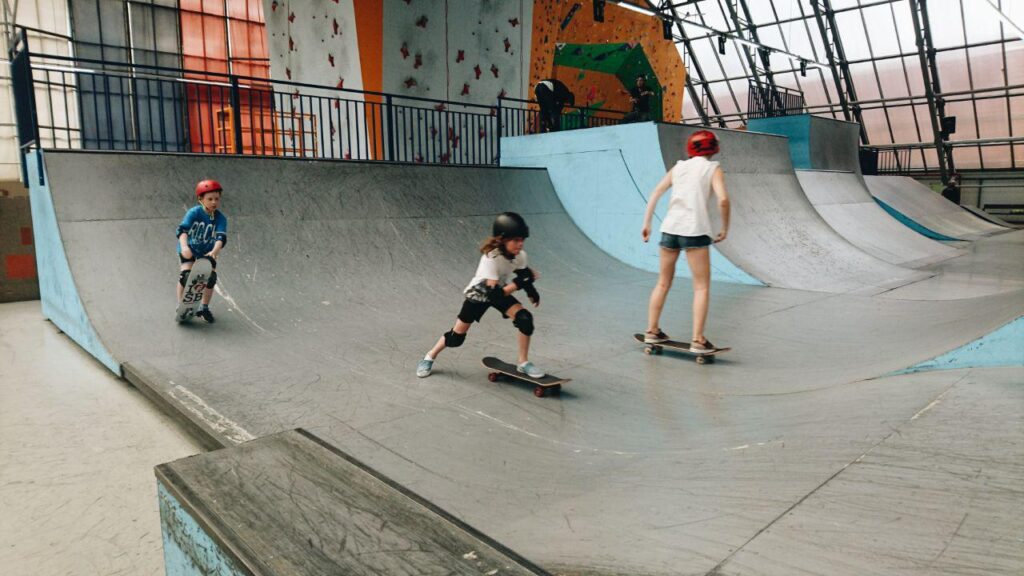Small group skateboarding session at an indoor skatepark with One2Flip